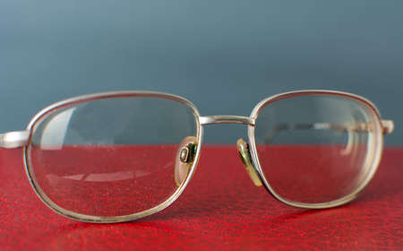 Reading glasses on top of red bookの写真素材