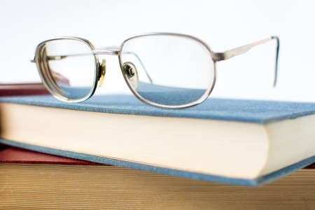 Reading glasses on top of blue bookの写真素材