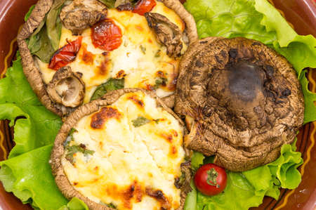 egg stuffed mushrooms on a brown plate with cherry tomatoesの写真素材