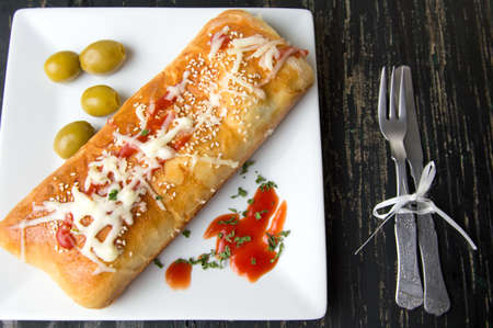 Homemade calzone pizza served on white plate