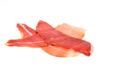 Prosciutto ham slice isolated on white backgroundの写真素材