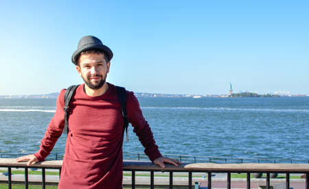 Tourist posing in front of the Statue of Liberty in New York