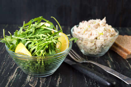 Arugula plant and chicken salad in glass bowlsの写真素材