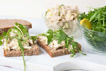 Chicken salad and arugula sandwich on wooden boardの写真素材