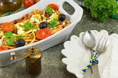 baked pasta with cherry tomatoes in a deep dishの写真素材