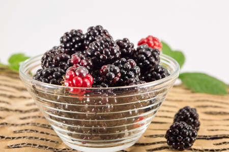 juicy blackberries and raspberries in a glass bowl