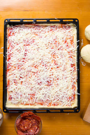 Pizza in making with ingredients, top viewの写真素材