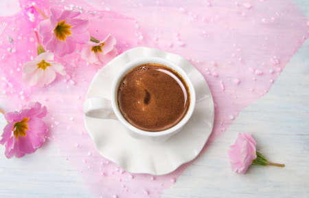 Cup of coffee and pink spring flowersの写真素材