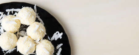 Coconut candy balls on a black plate