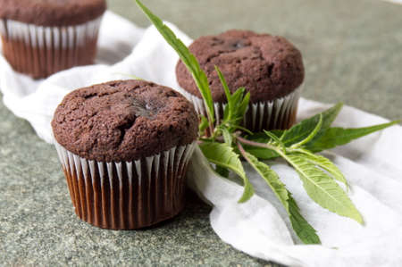 Chocolate muffins with Marijuana leaves on stone tableの写真素材
