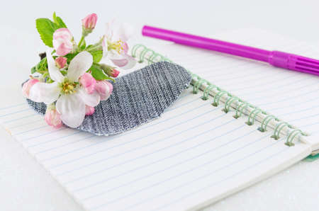 Denim heart on open notebook with spring blossom flowersの写真素材