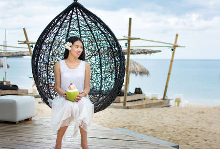 Girl with fresh coconut at the tropical beach resortの写真素材