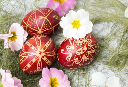 Easter eggs decorated with wax and flowers on straws