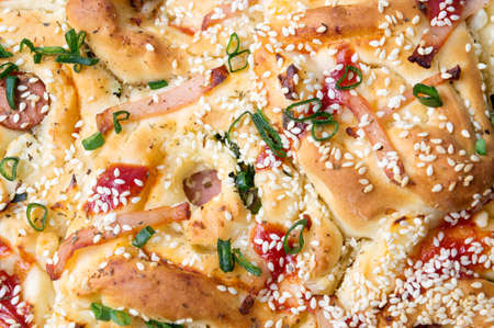 Pizza bread with sesame, onions and ham