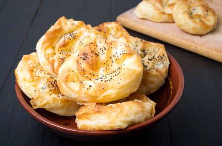 Homemade cheese pie rolls covered with sesame on a plate