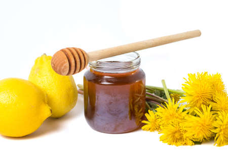 Dandelion honey and fresh flowers on whiteの写真素材