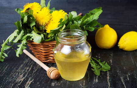 Honey with dandelion flowers and lemon fruitの写真素材