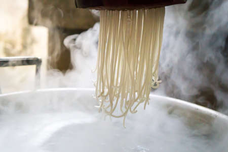 Traditional noodles making procedure on a vintage machineの写真素材