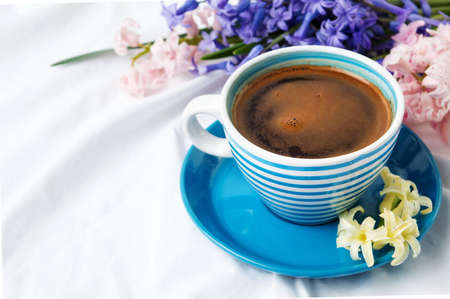 Cup of coffee and colorful hyacinth flowers