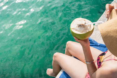 Woman with coconut on a tropical destinationの写真素材