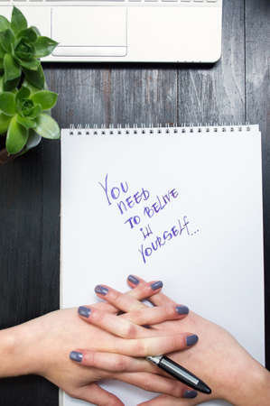 Female cracking fingers while writing motivational messageの写真素材