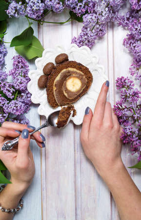 Girl eating chocolate banana cake on lilac decorated tableの写真素材