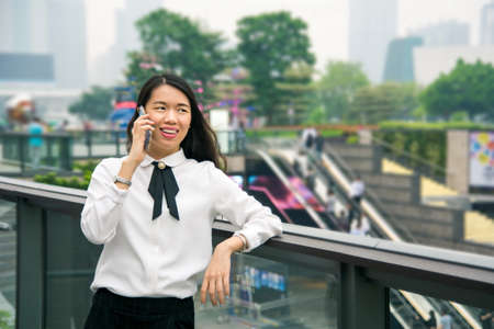 Business woman on the phone in modern environment outsideの写真素材