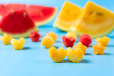 Shaped yellow and red watermelon slices on blue backgroundの写真素材