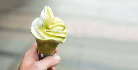 Male hand holding green tea ice cream point of viewの写真素材