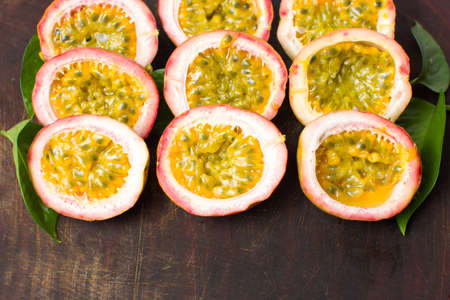 Bunch of halved passion fruit on a wooden boardの写真素材