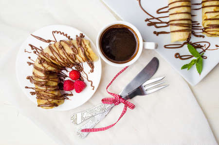 Pancakes with strawberry and chocolate on a white plateの写真素材