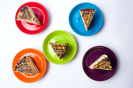 Caramel cake slices served on colorful platesの写真素材