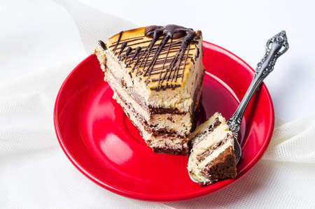 Caramel chocolate cake slice on a red plate