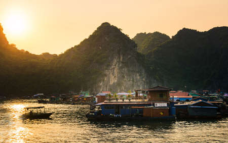 CAT BA, VIETNAM - MAY 27, 2017: Fisherman village of houses on water and boats near Cat ba island at sunsetのeditorial素材