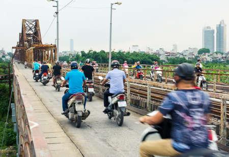 HANOI, VIETNAM - MAY 24, 2017: People on motorbikes crossing the  Long Bien bridge in Hanoi, which connects two parts of the city across the Red riverのeditorial素材