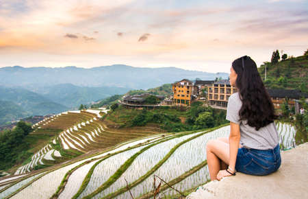 Girl enjoying sunset at terraced rice field in Longji, Guilin area, Chinaの写真素材