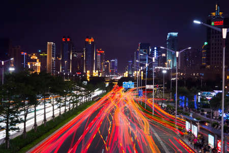 NANNING, CHINA - JUNE 9, 2017: Qingxiu District busy traffic with light trails and high illuminated  buildings. Nanning is the capital city of Guangxi province and an example of fast development in Chinaのeditorial素材