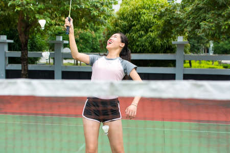 Asian girl playing badminton on the outdoors courtの写真素材