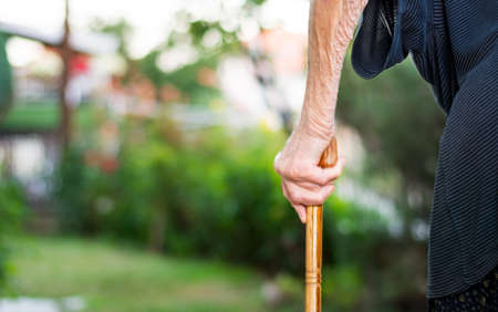 Senior woman walking with a cane outdoorsの写真素材