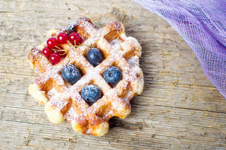 Homemade waffle with fresh berry fruit on a tableの写真素材
