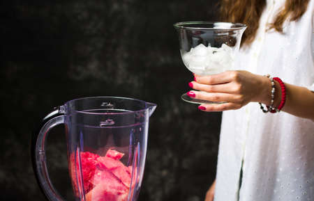 Female adding ice into blender for a watermelon smoothieの写真素材