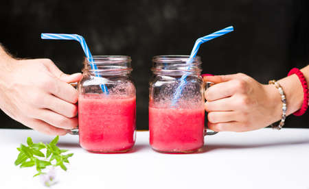 People holding glasses with healthy watermelon smoothieの写真素材
