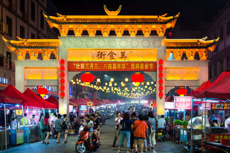 PINGXIANG, CHINA - MAY 21, 2017: Traditional Chinese gate leading into popular food street crowded with people. Pingxiang is the border city of China and Vietnam, in Guangxi provinceのeditorial素材