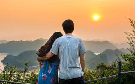 Couple enjoying sunset at romantic seaside viewpointの写真素材