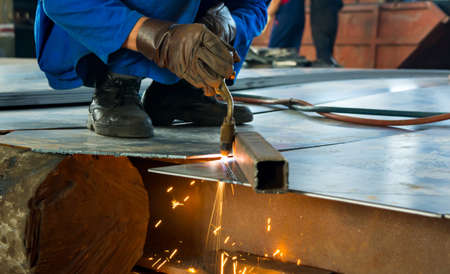 Man cutting metal with fire from a welding cutting torch