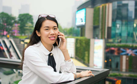 Business woman on the phone in modern environment outsideの写真素材