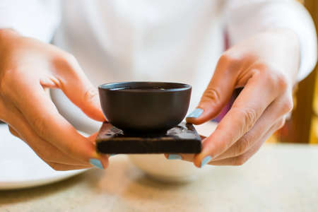 Girl having cup of  tea at Chinese restaurantの写真素材