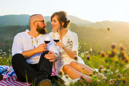Happy couple drinking wine on a picnicの写真素材