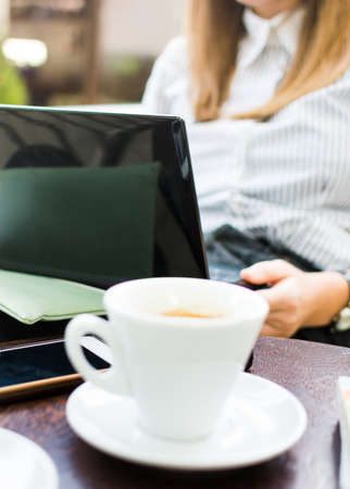 Woman using laptop computer at a coffee barの写真素材