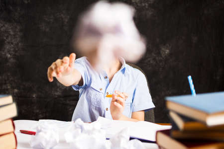 Boy throws away papers with homework assignment failureの写真素材